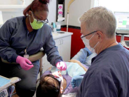Dr. Kitzmiller and assistant work on patient to place a CEREC crown Dr. Kitzmiller and assistant work on patient to replace crown using CEREC